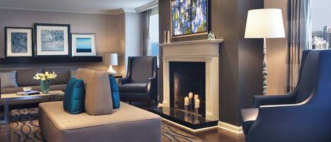 A modern living room with a fireplace, seating area, and artwork on the walls.