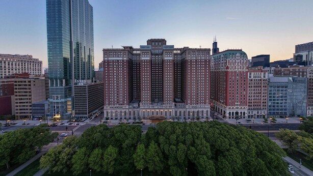 Un edificio grande e histórico con un patio central rodeado de árboles.