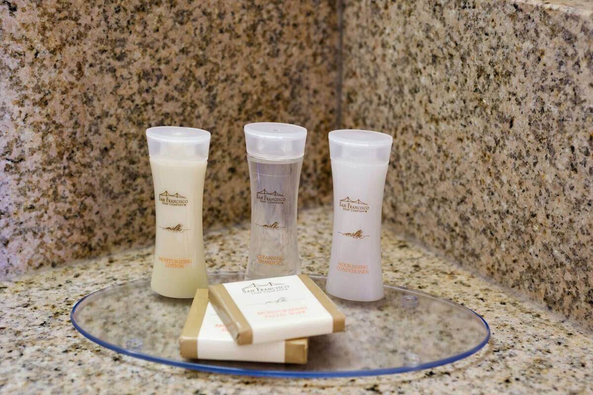 Three bottles of skincare products on a granite countertop.
