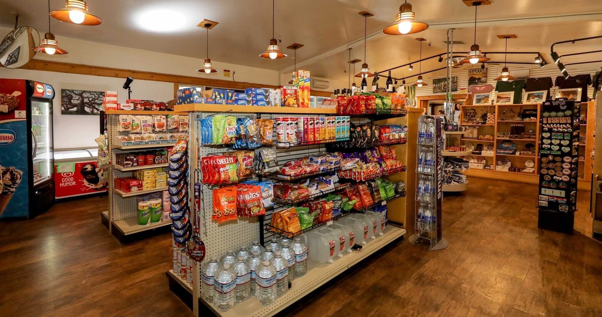A store with shelves stocked with snacks, beverages, and a display of various items.
