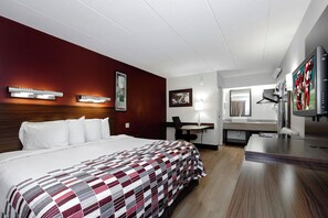 A hotel room with a bed, desk, chair, TV, and a mirror. - Red Roof Inn Aberdeen (Aberdeen)