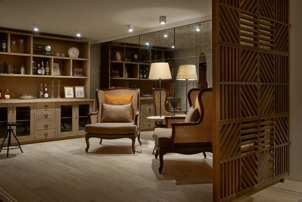 Habitación bien iluminada con muebles de madera, un separador de vidrio y varios objetos decorativos en estantes.