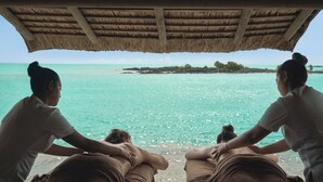 A beachside massage area with a thatched roof, overlooking turquoise waters and a small island. - Paradise Cove Boutique Hotel - Adults only (Cap Malheureux)