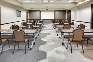 A conference room with rows of tables and chairs, equipped with water bottles and presentation screens. - Hyatt Place Nashville Opryland (Nashville)