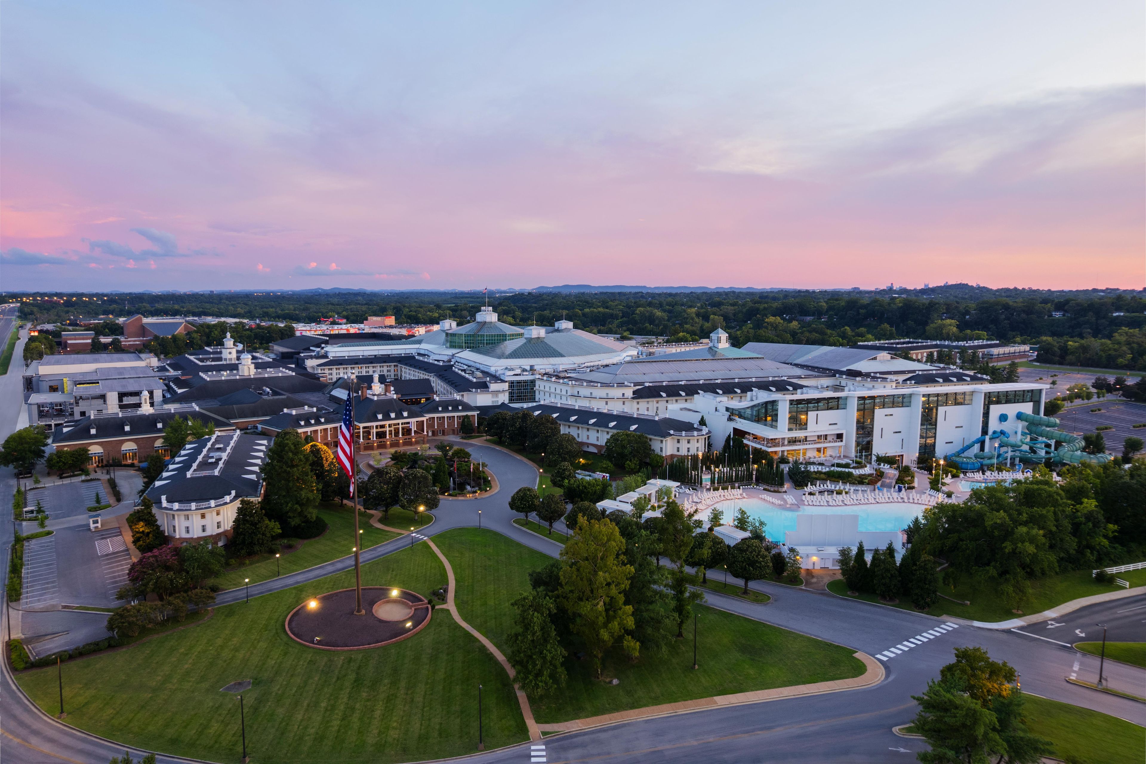 A large hotel complex with multiple buildings, a swimming pool, and a landscaped area with a circular driveway.