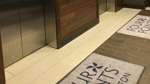 A modern elevator with a digital display and a wooden panel design. - Radisson Hotel Detroit Metro Airport (Romulus)