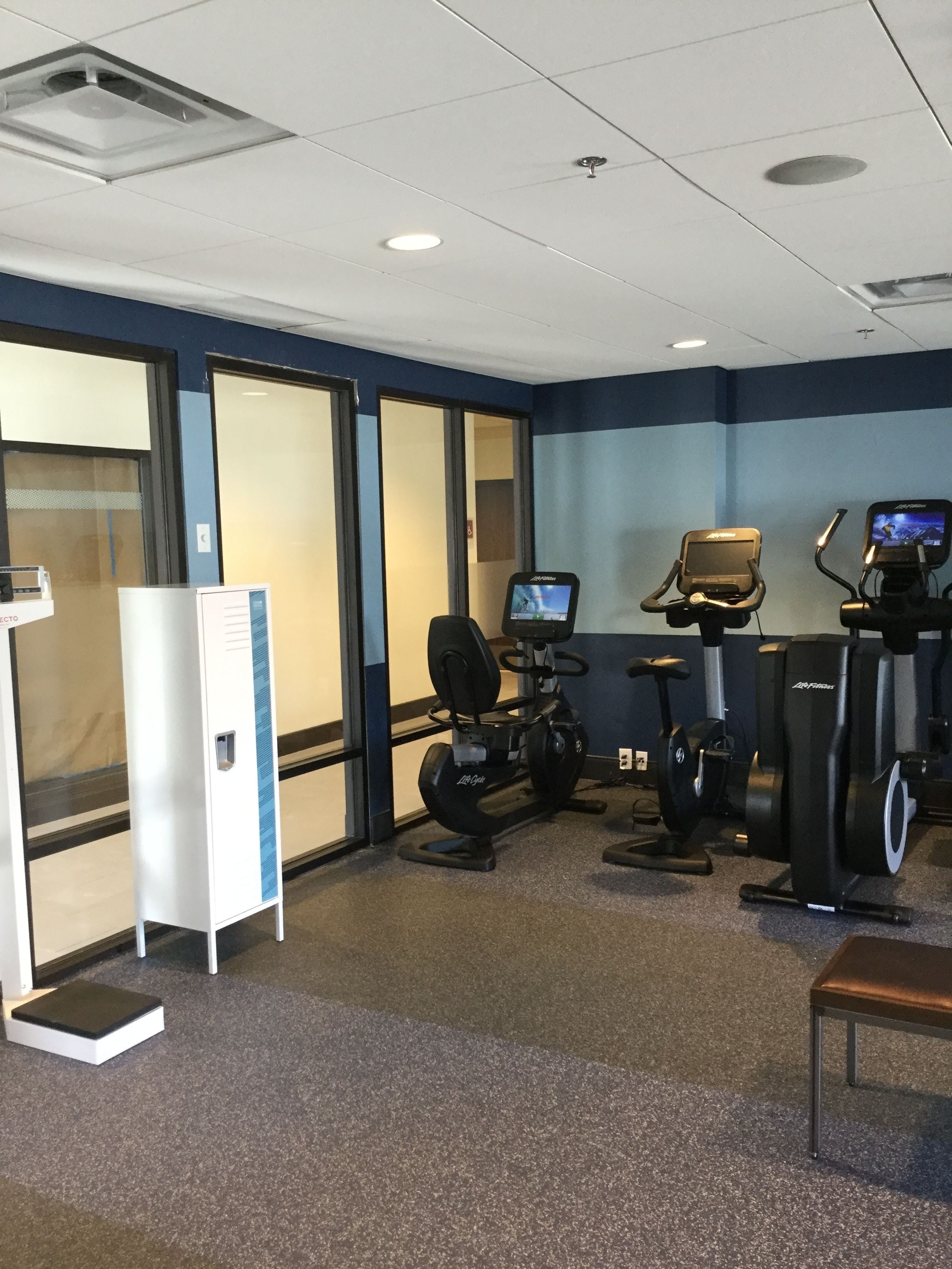 A gym with cardio machines, a treadmill, and a stationary bike.