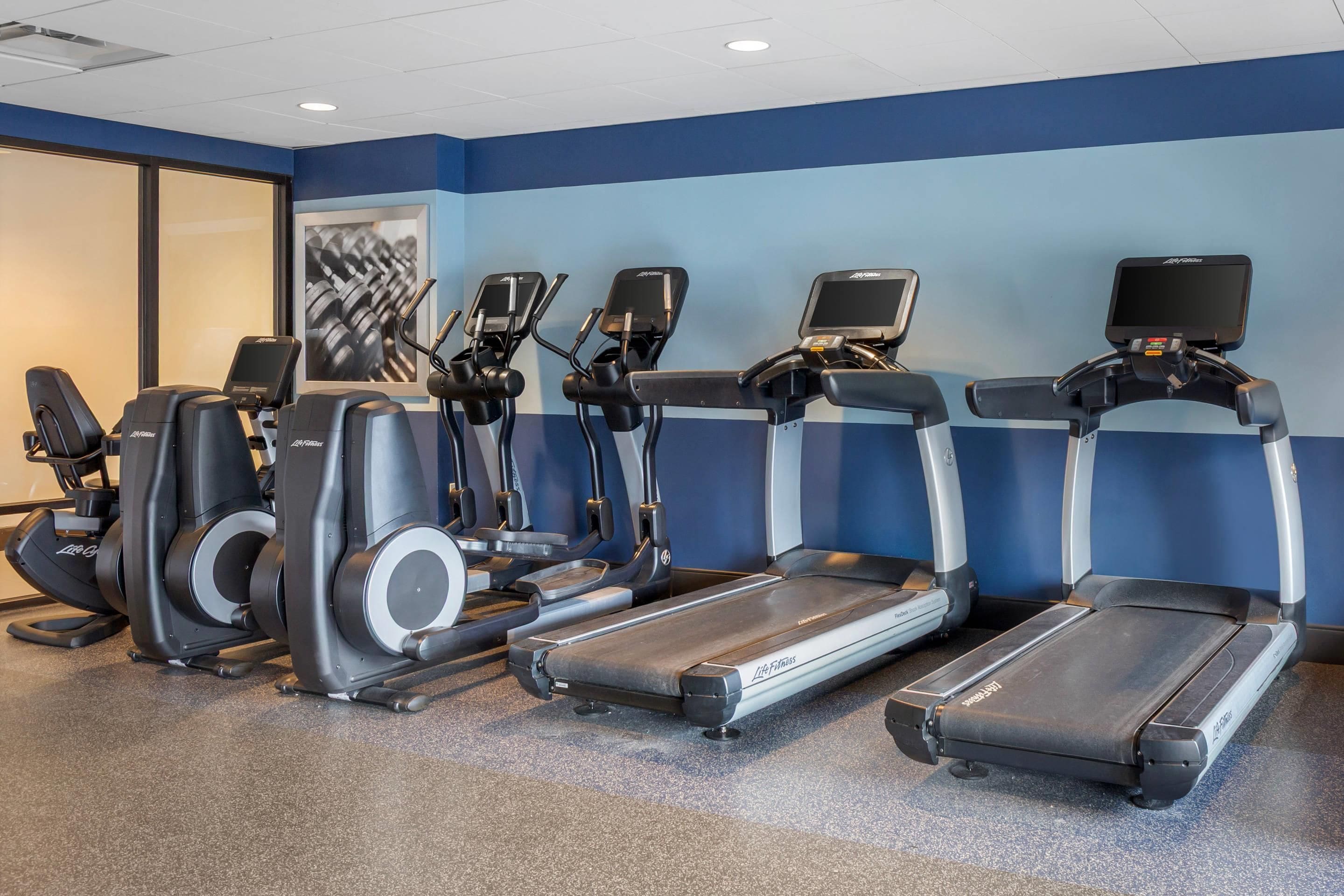 A fitness center with treadmills, elliptical machines, and stationary bikes.