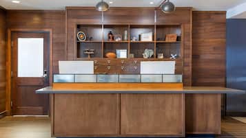 A modern kitchen with wooden cabinetry, a central island with a built-in sink, and overhead pendant lighting.