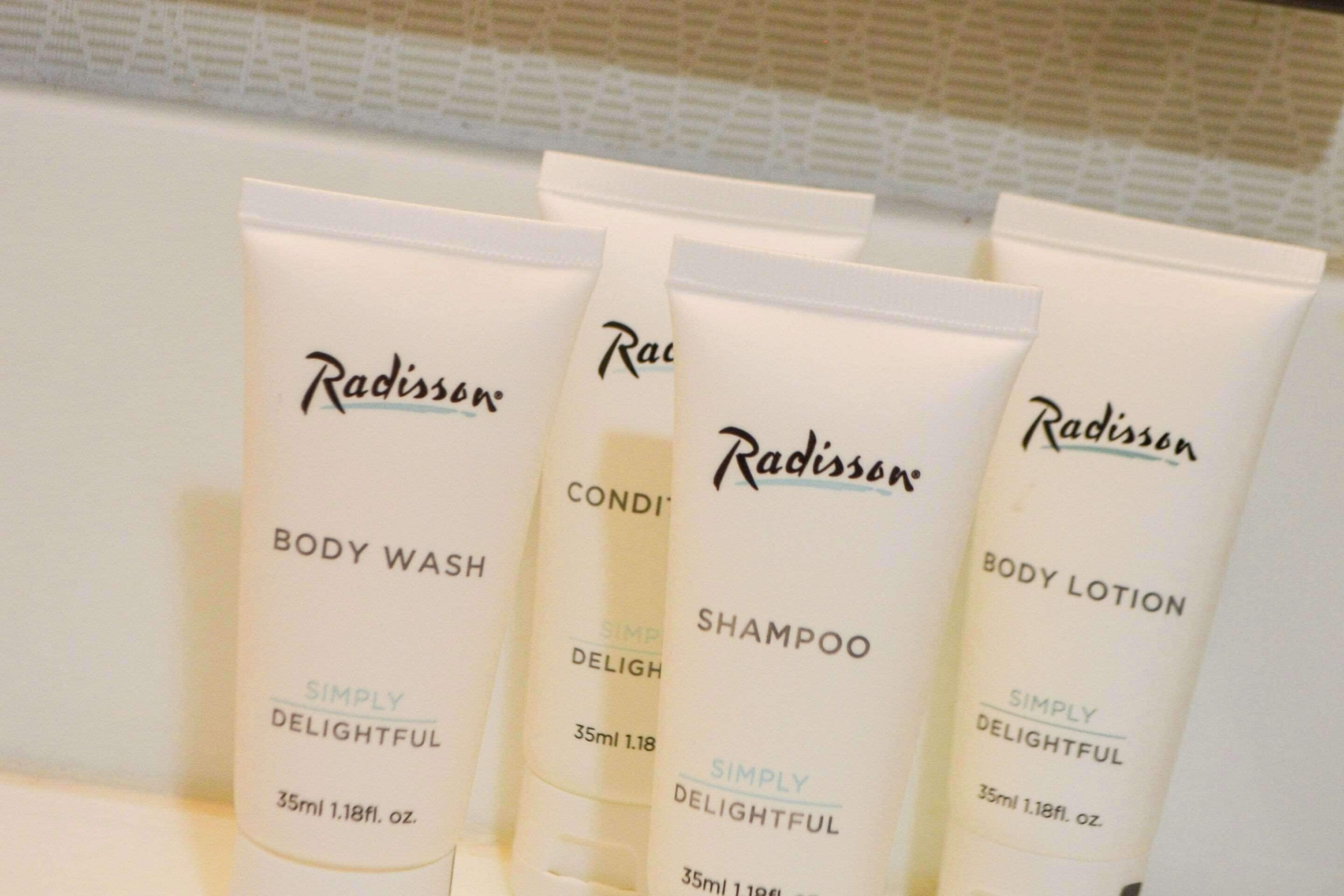 A row of Radisson body care products including body wash, shampoo, and body lotion.