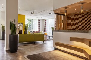 A modern interior with a staircase, a sofa, and a dining area.