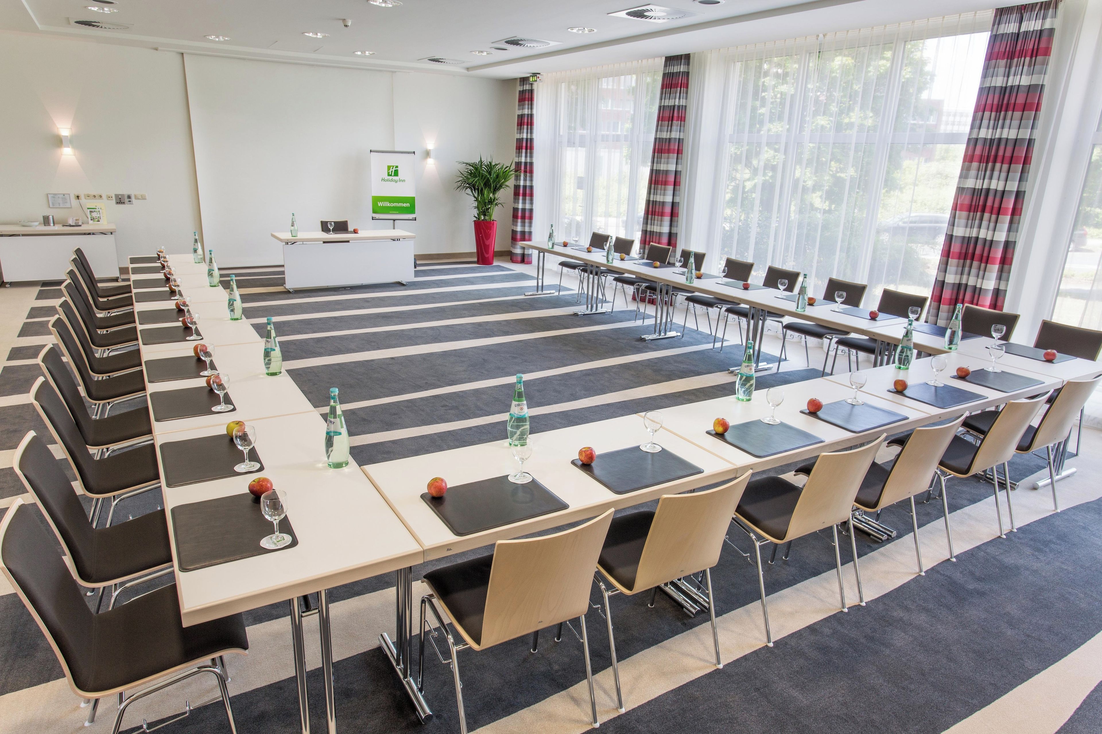 A conference room with a long table, chairs, and a reception desk.