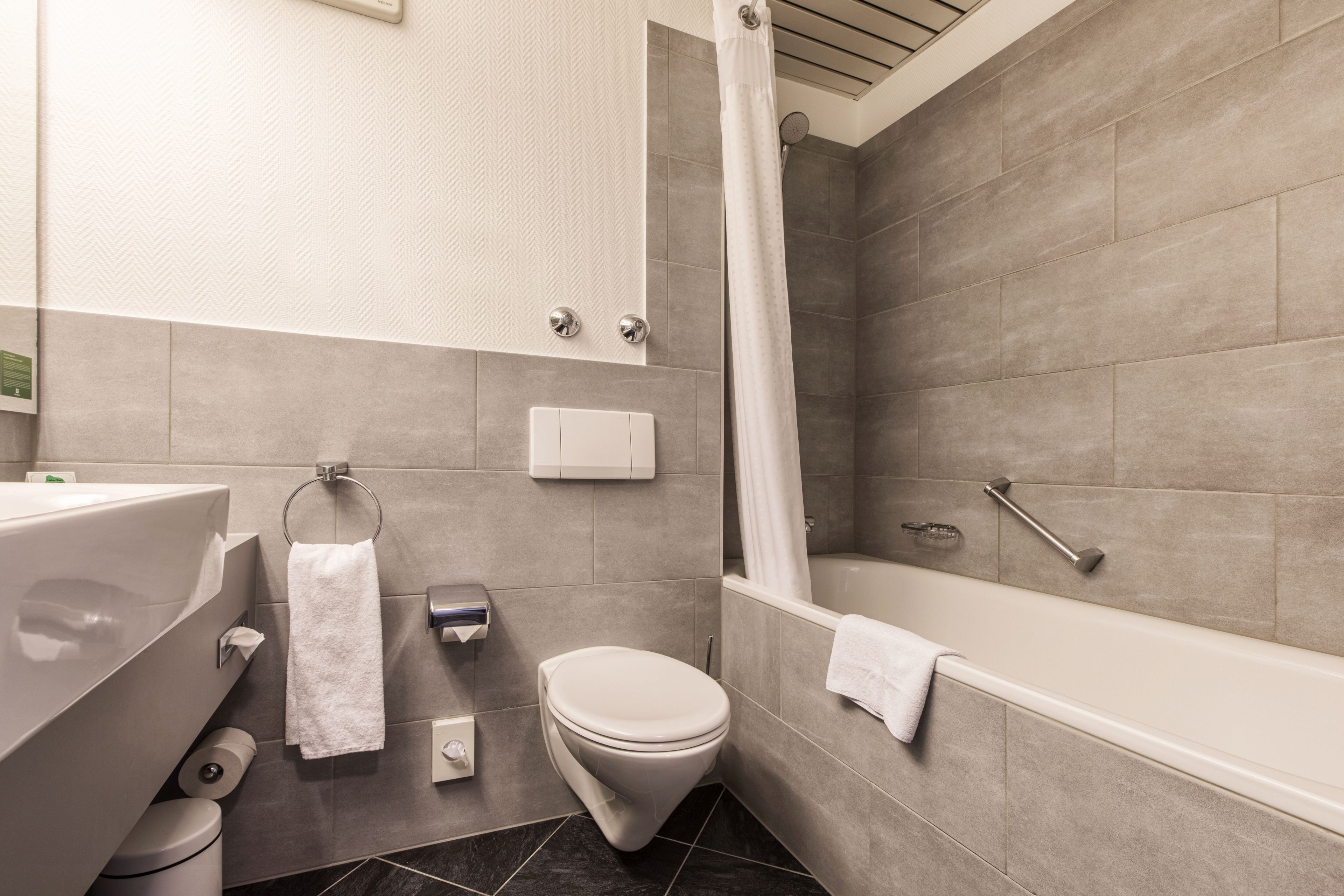 Une salle de bain moderne équipée d’une baignoire, de toilettes et d’un espace douche.