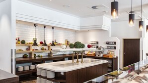 Una cocina moderna con una isla central, azulejos blancos tipo metro e iluminación colgante.
