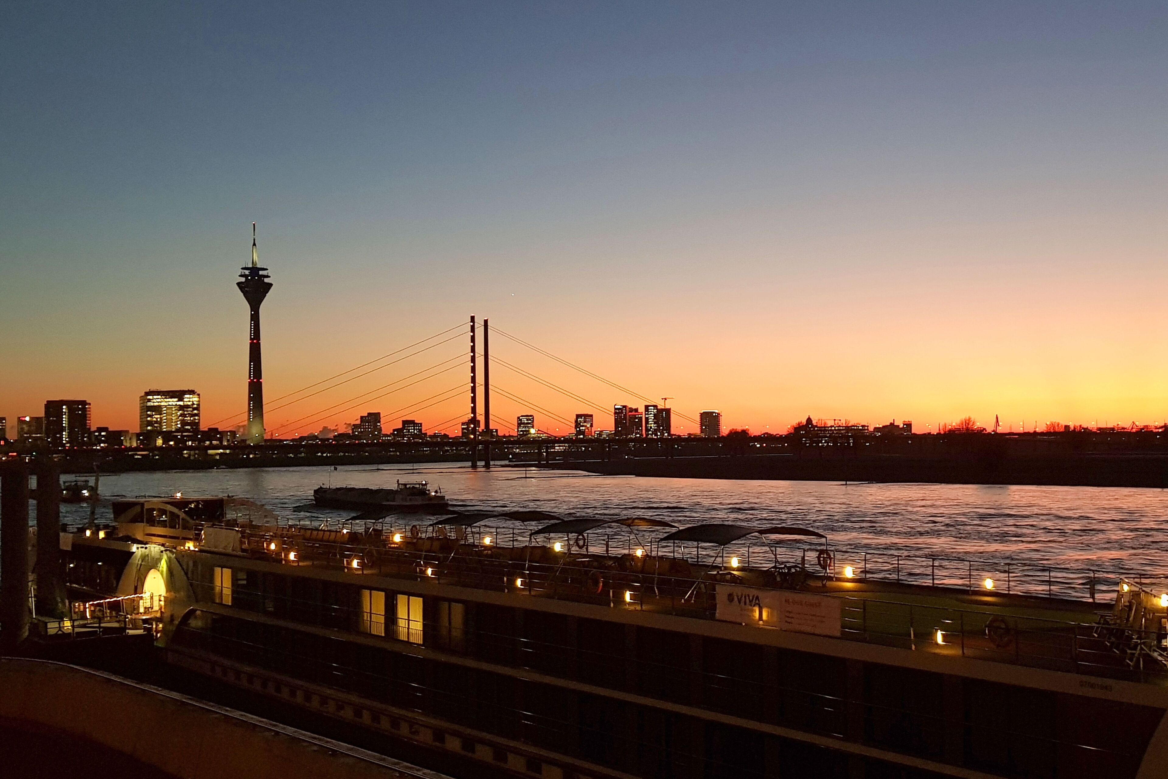 A river with a bridge and a tower in the background.