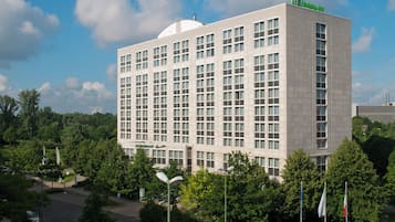Ein großes, mehrstöckiges Holiday Inn Hotel mit flachem Dach und einem auffälligen grünen Logo oben.