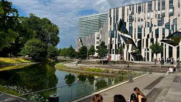 Un edificio moderno con una fuente acuática reflectante en primer plano.