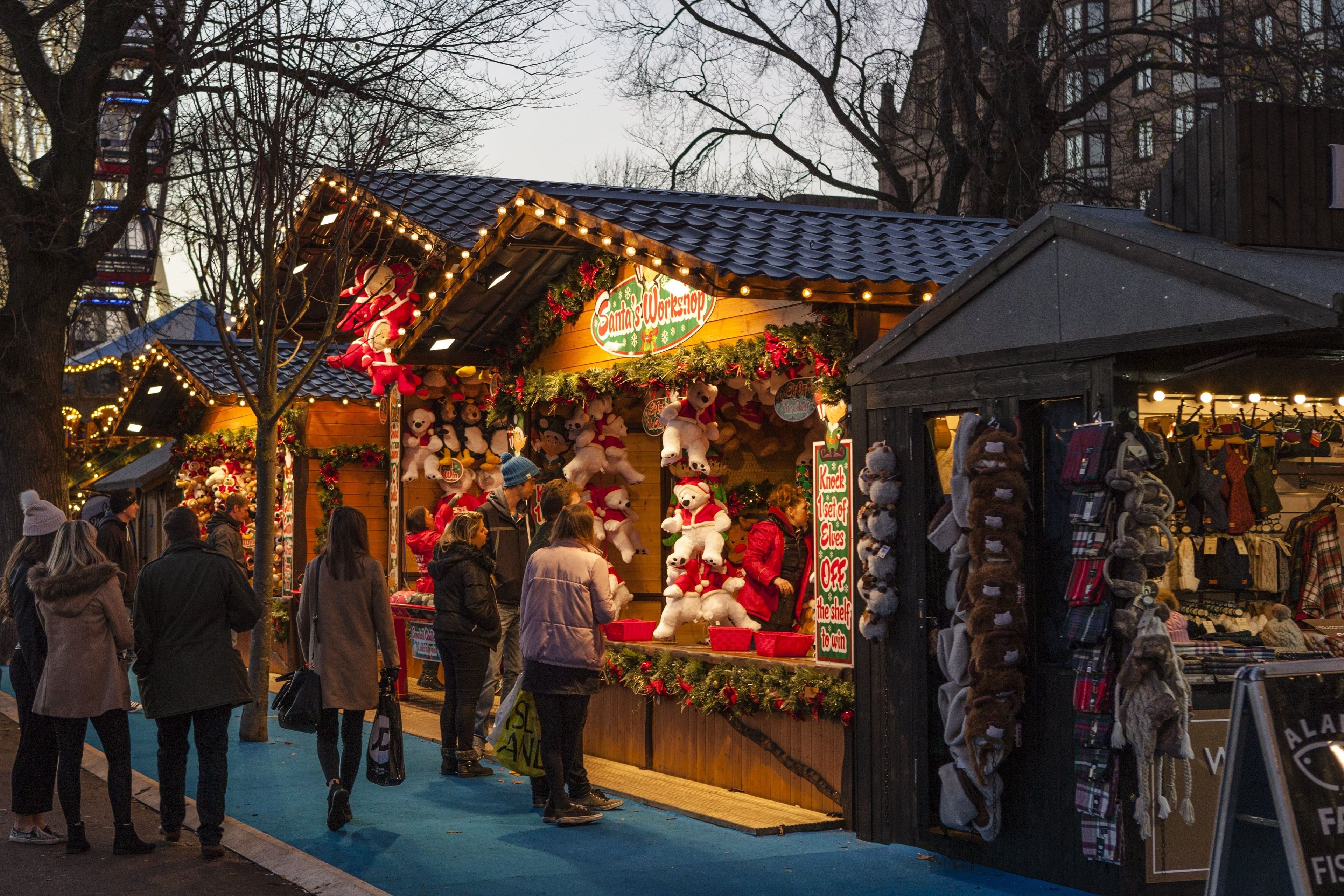 Un puesto de mercado adornado con decoraciones navideñas y peluches.