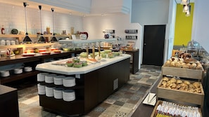 A buffet setup with various food items and a coffee station.