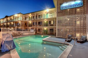 Una piscina al aire libre, sillones reclinables de piscina