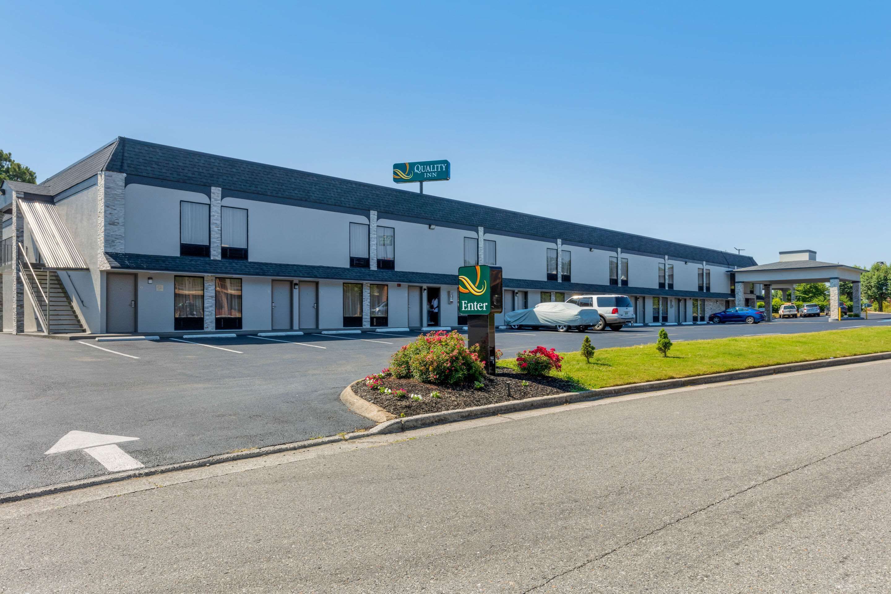 Un motel avec une enseigne indiquant « Quality Inn » et un panneau « Entrée ».