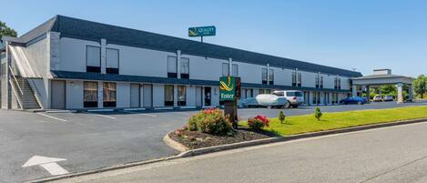 Un motel avec une enseigne indiquant « Quality Inn » et un panneau « Entrée ».