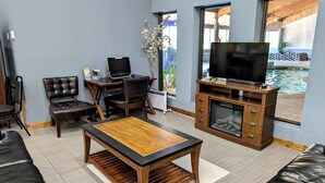 Una sala de estar moderna con una mesa de centro de madera, sofás de cuero, un televisor y una chimenea.