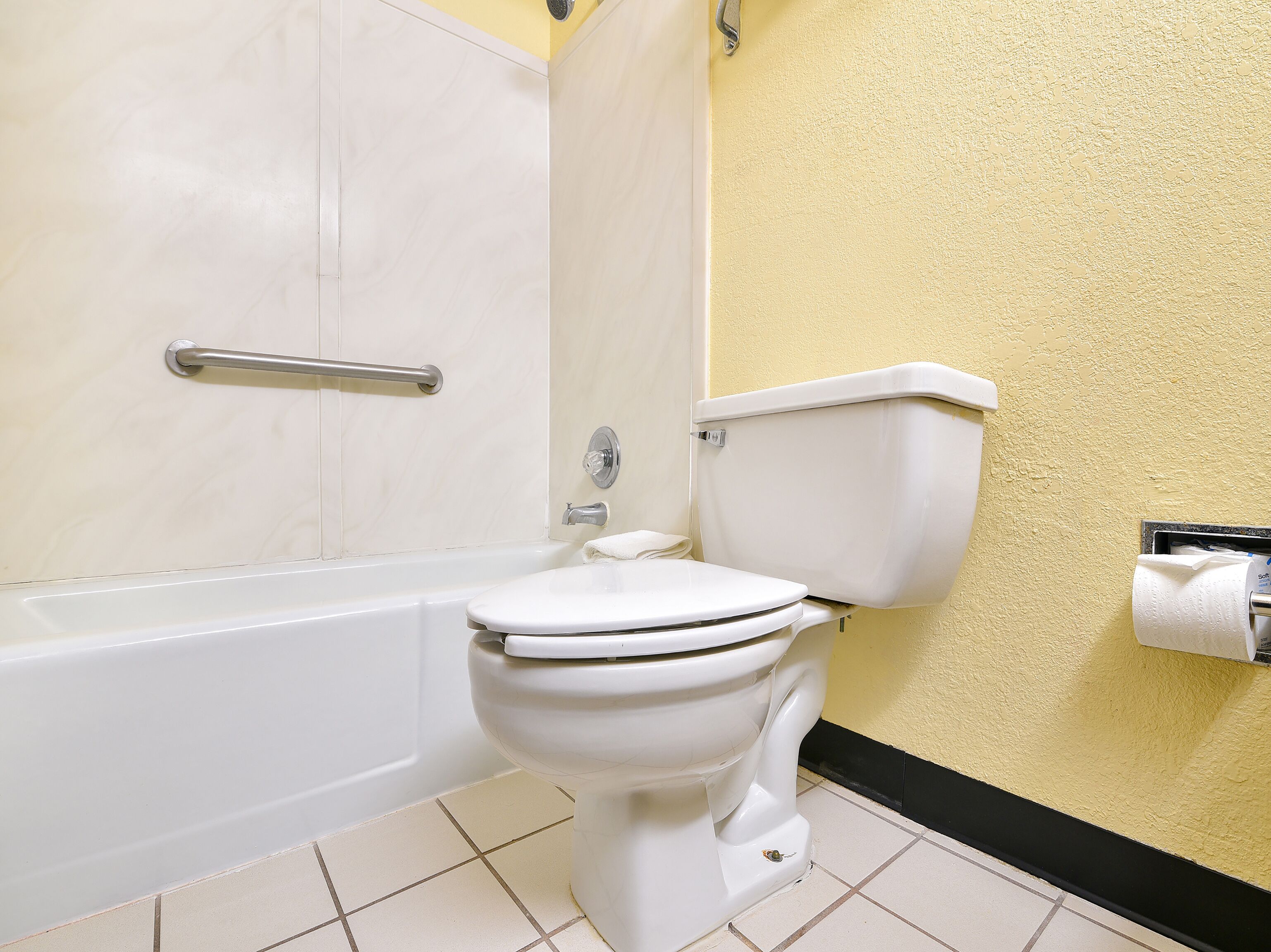 Un baño con inodoro, bañera y zona de ducha.