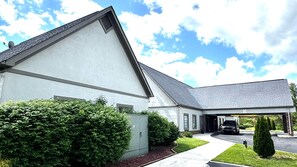 Stunning two-story home with a gabled roof and covered garage, set amidst a beautifully manicured lawn.