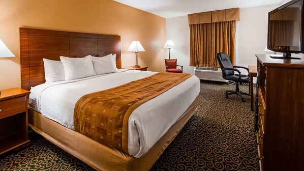 Relax in this inviting room featuring a large bed, a desk, and a television.