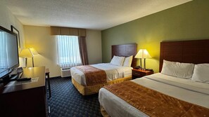 Two single beds with matching headboards and footboards, a flat-screen TV, and a desk with a lamp.