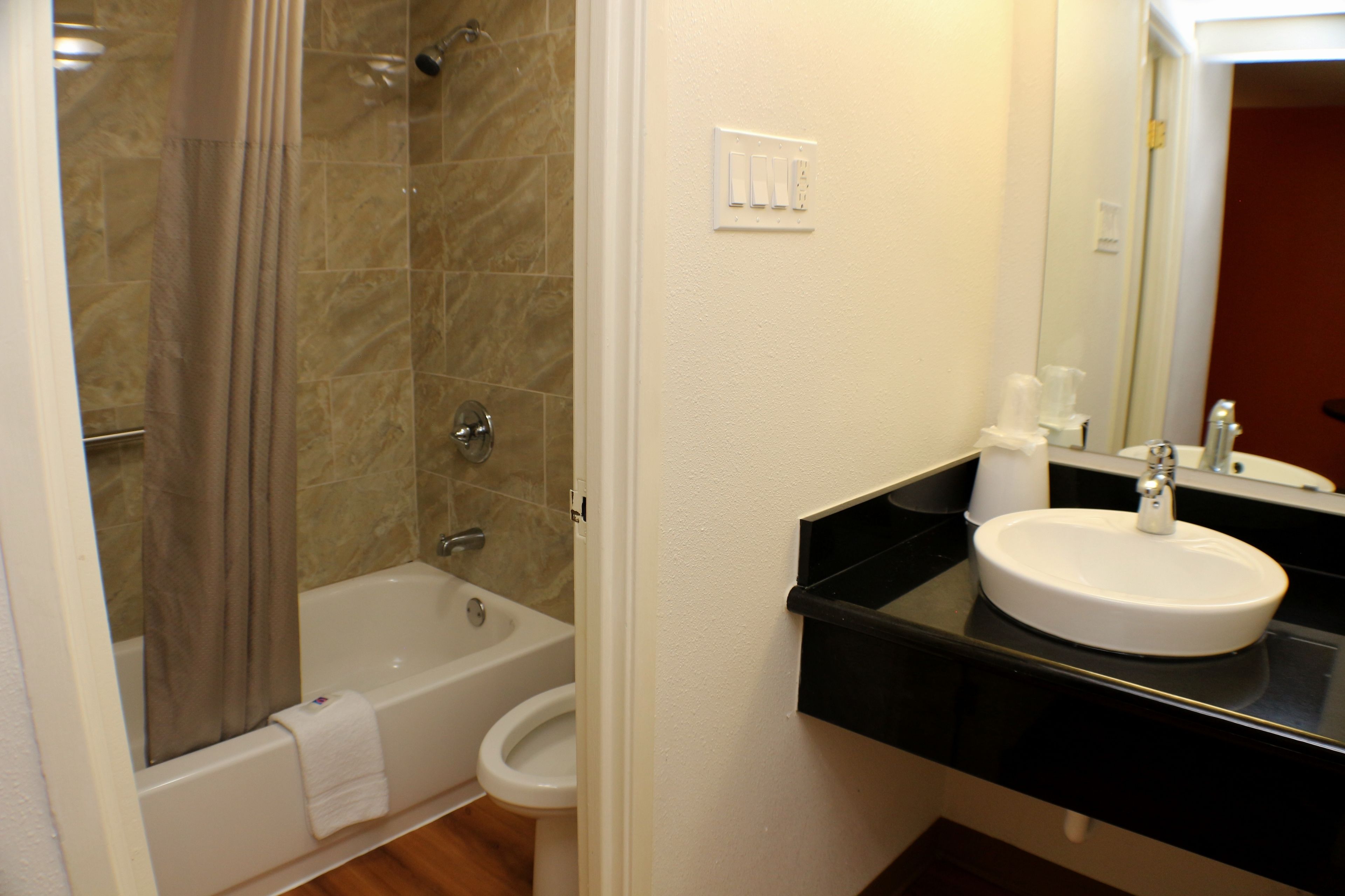 Un baño con bañera, inodoro y lavamanos.