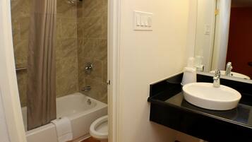 A bathroom with a bathtub, toilet, and sink.