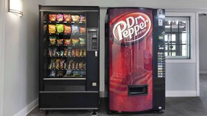 Two vending machines, one with a variety of snacks and the other branded with Dr Pepper. - Motel 6 Beaumont, TX (Beaumont)