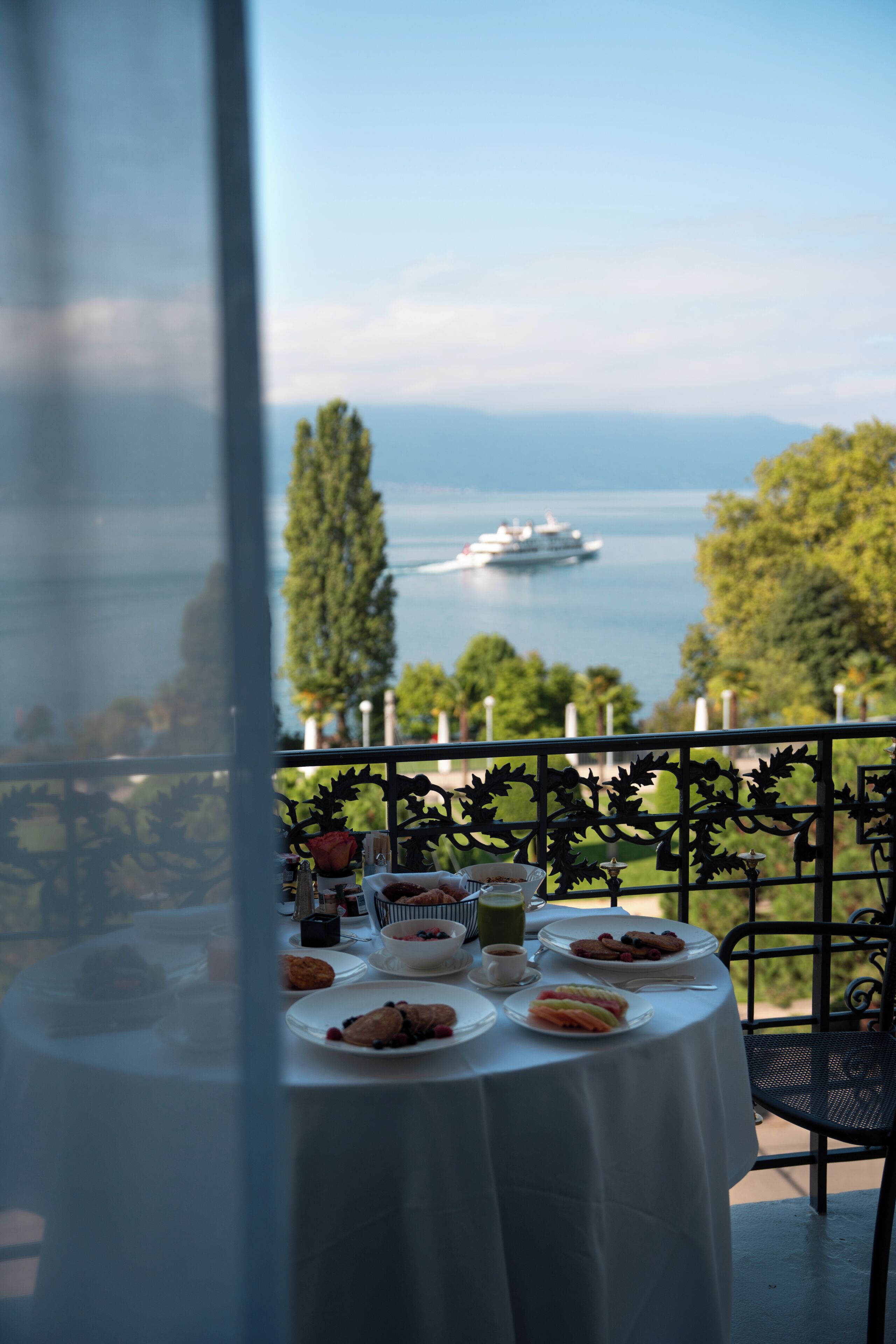 A table with breakfast items and a view of the sea.