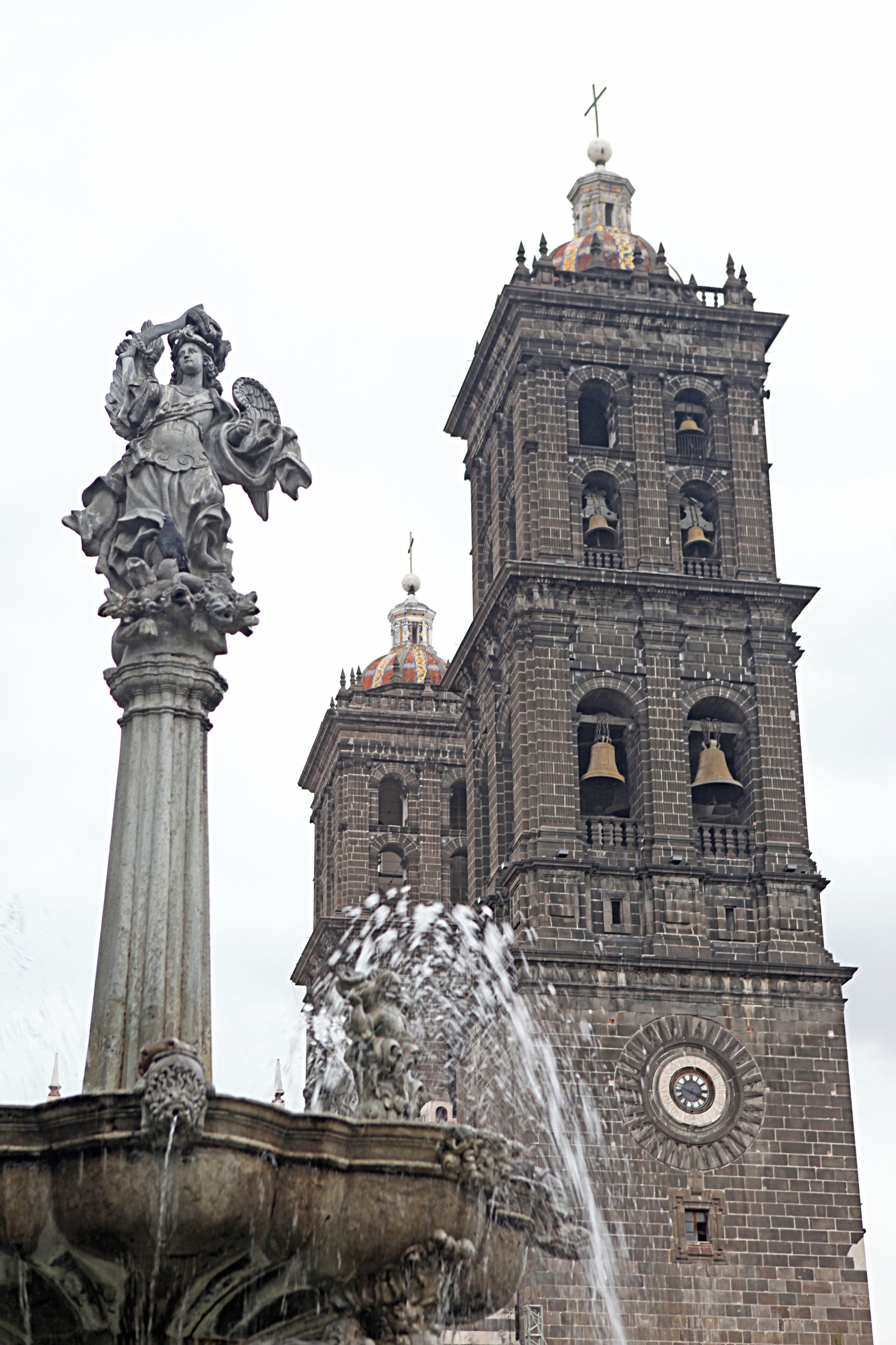 Una església antiga amb una torre campanar i una font.