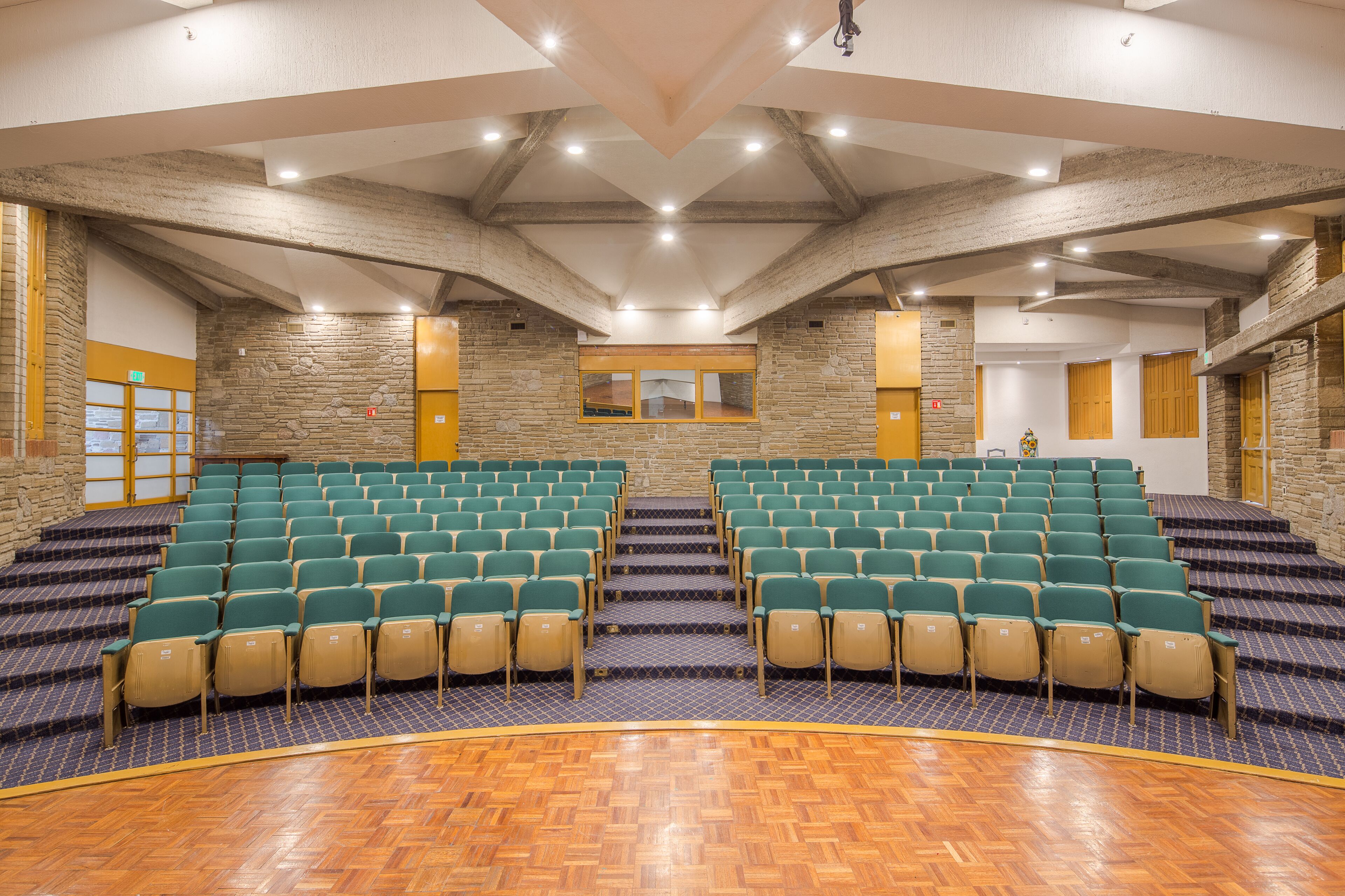 Een congreszaal met trappartikelen, stenen muren en houten vloeren.