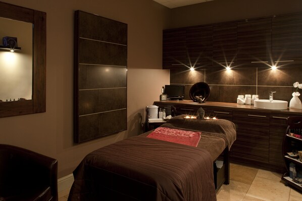 Une chambre à coucher moderne avec un grand lit, une coiffeuse avec un miroir et un téléviseur.