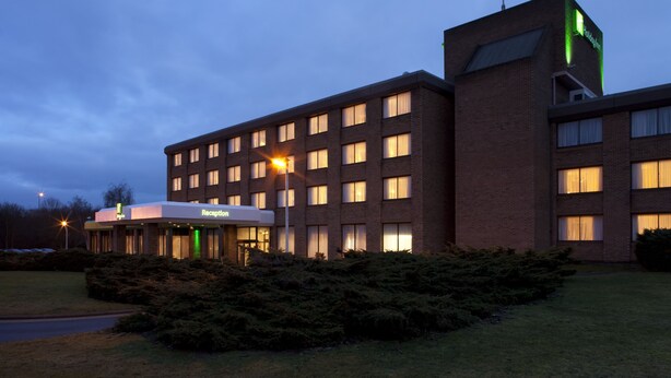 Un hôtel doté d’un hall d’accueil, de plusieurs étages et d’une façade bien éclairée.