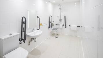 A modern bathroom with a toilet, sink, and shower.