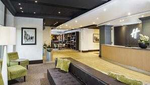 Un hall d’entrée moderne doté d’espaces de détente, d’un comptoir d’accueil et d’un bar/salon.