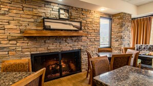 Un restaurante con paredes de piedra, chimenea y muebles de madera.