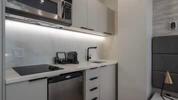 Una cocina moderna con microondas integrado, máquina de café y lavavajillas.