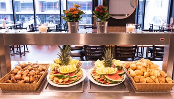 A buffet with various food items including pastries, fruits, and a candle.