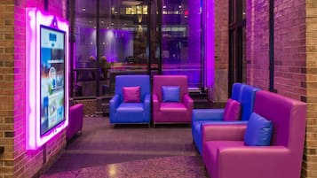 A modern lounge area with seating and a digital kiosk.
