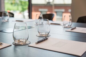 A conference table with empty wine glasses, a pen, and a notepad.