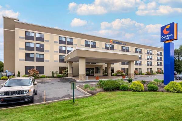 A Comfort Inn hotel with a flat facade, multiple windows, and a parking lot.