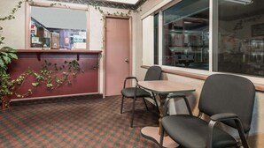 A room with a checkered carpet, a window with a view of the outside, a door, and a mirror on the wall. - Knights Inn Ottawa (Ottawa)