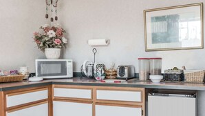 A kitchen with a microwave, toaster, and various kitchen items on the counter. - Knights Inn Ottawa (Ottawa)