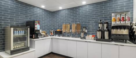 A self-service coffee station with a refrigerated display, beverage dispensers, and a coffee machine.